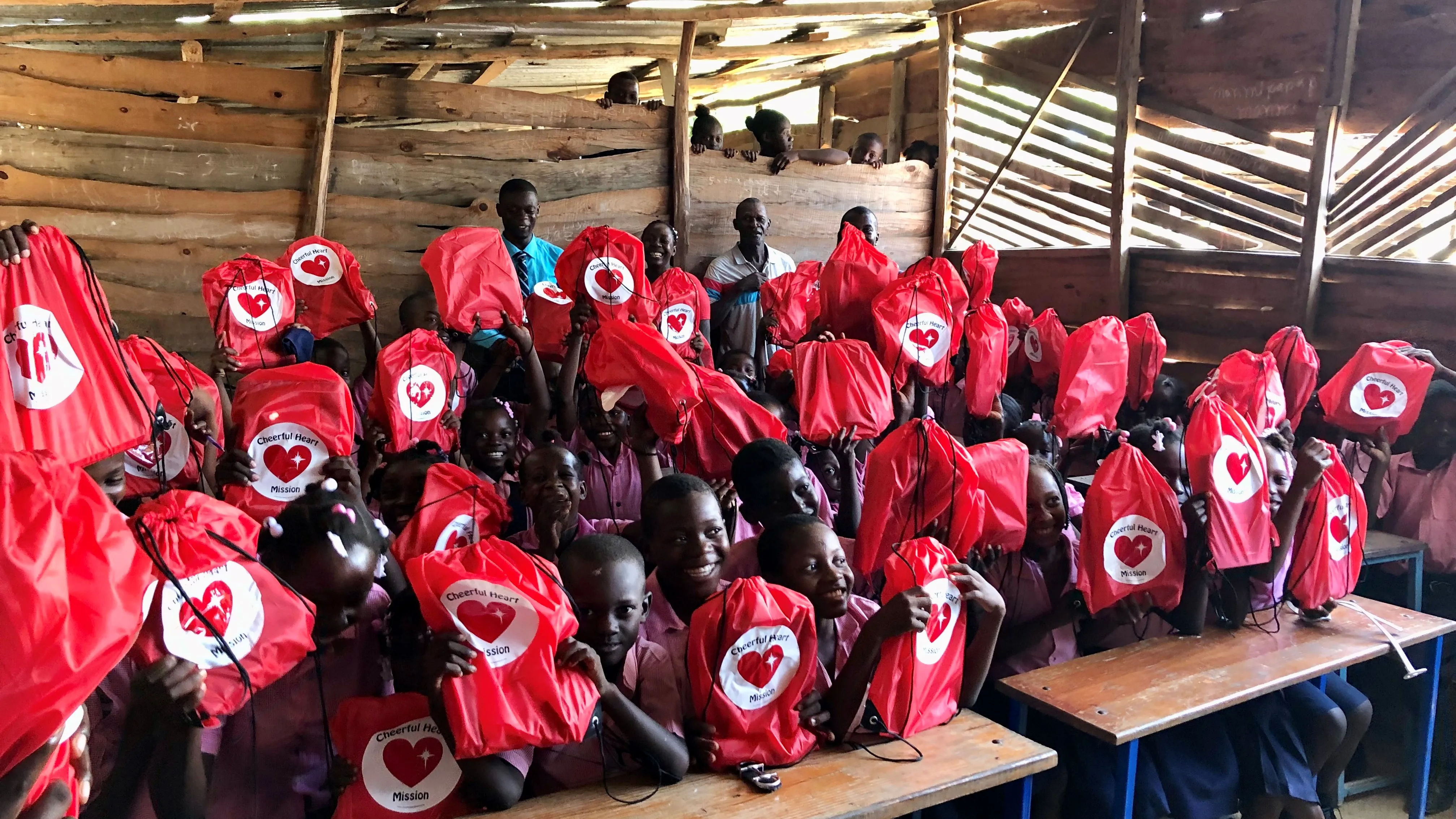 A classroom of students celebrates their new backpacks