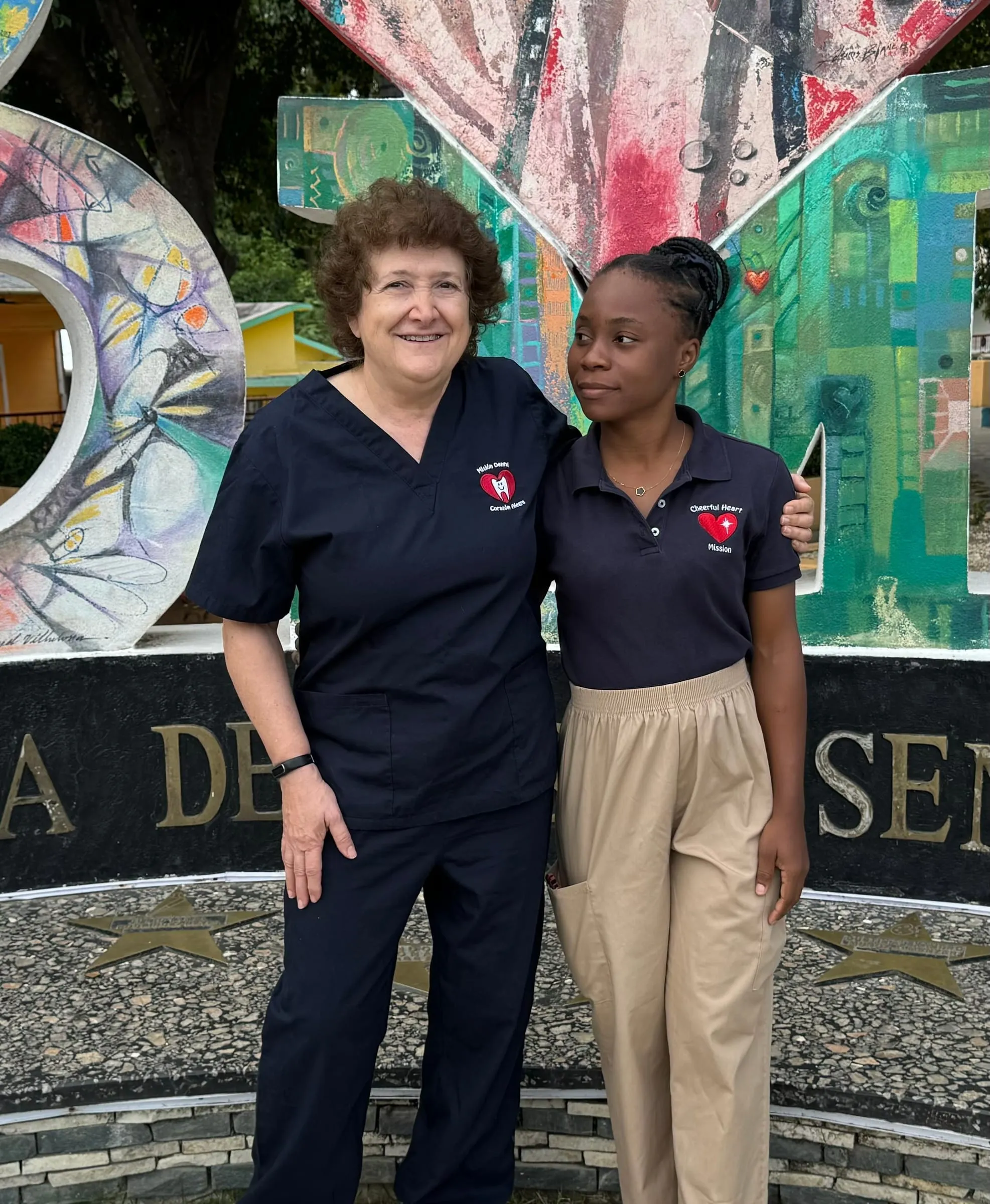 Two volunteers at a city mural sign