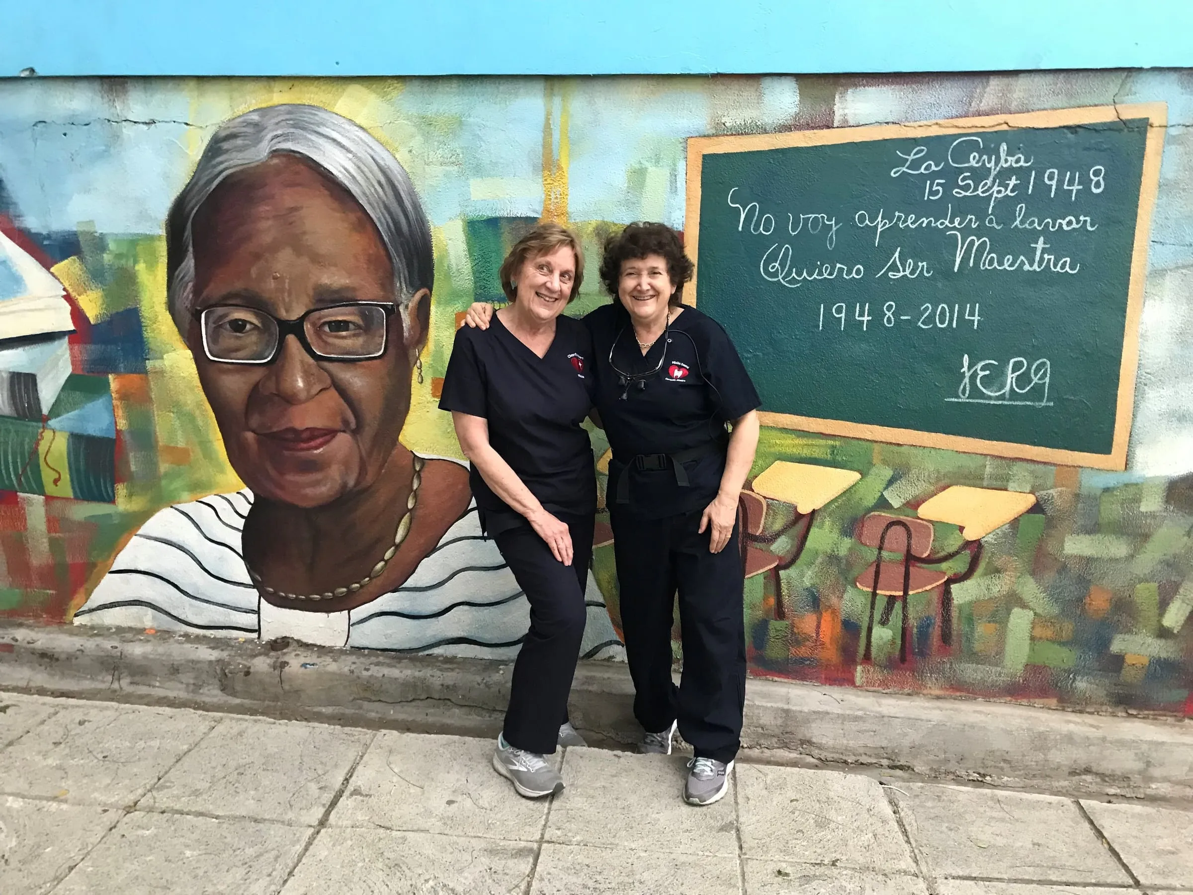 Two volunteers at a teacher mural