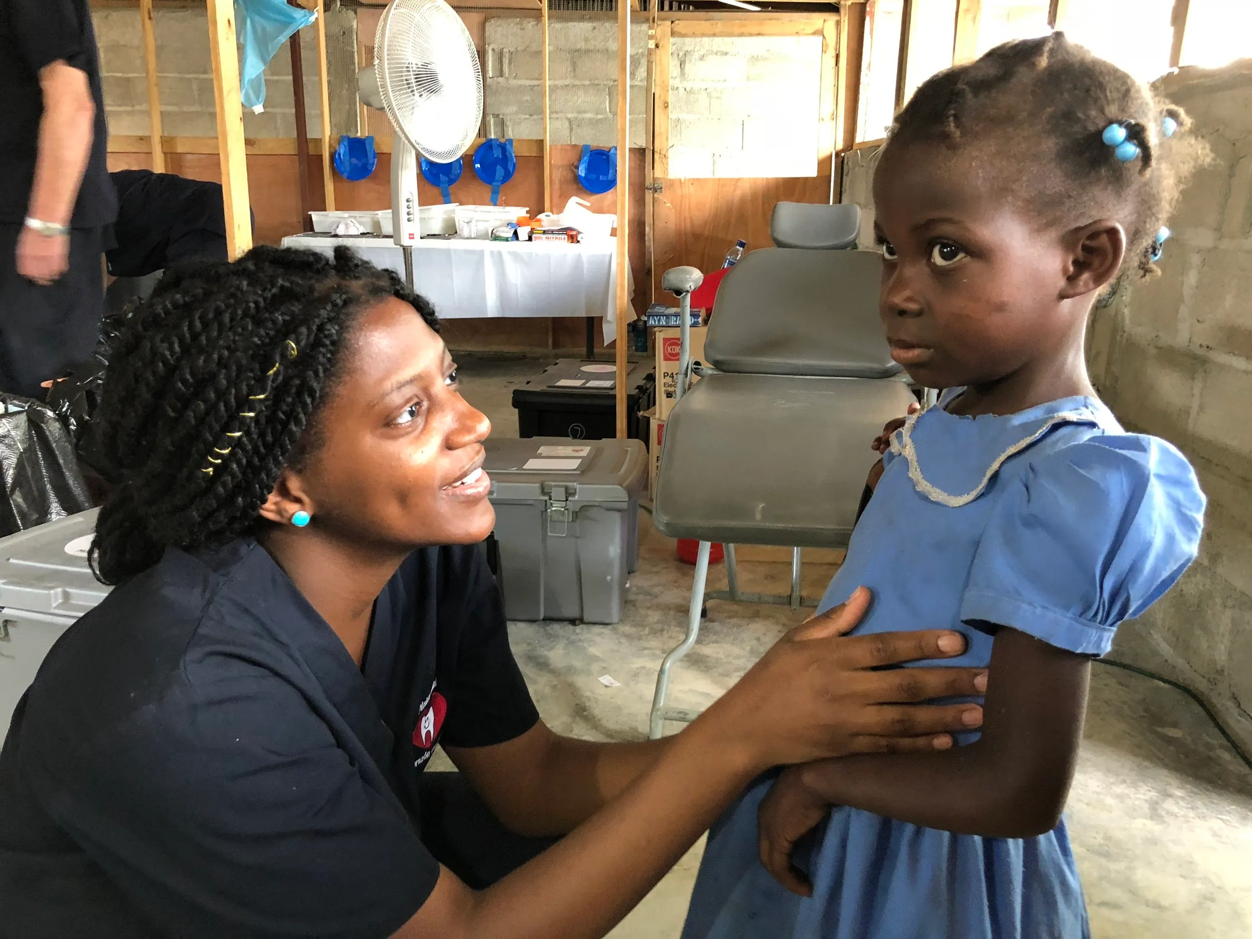 A volunteer comforts a young patient