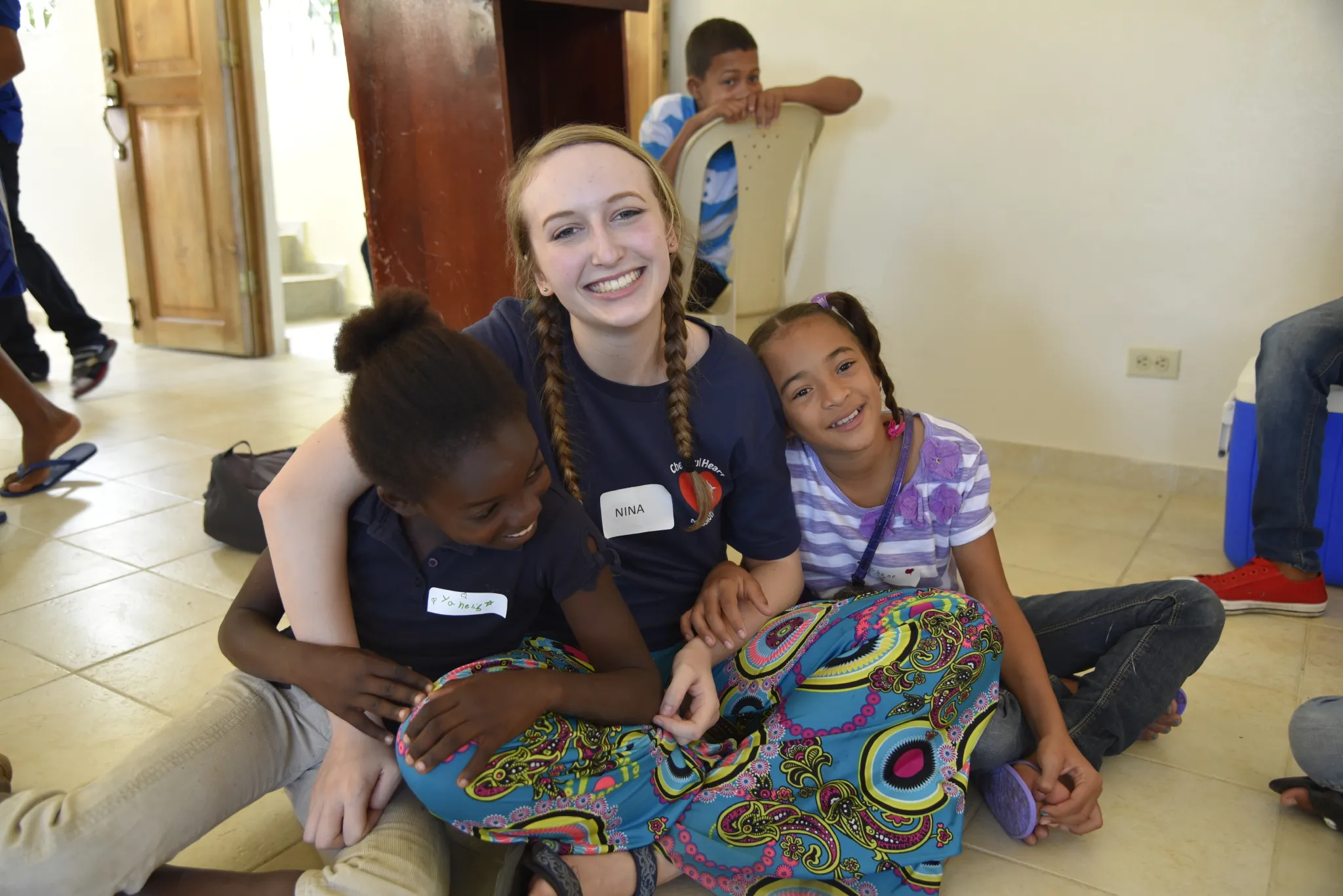 A music mission volunteer with two young students