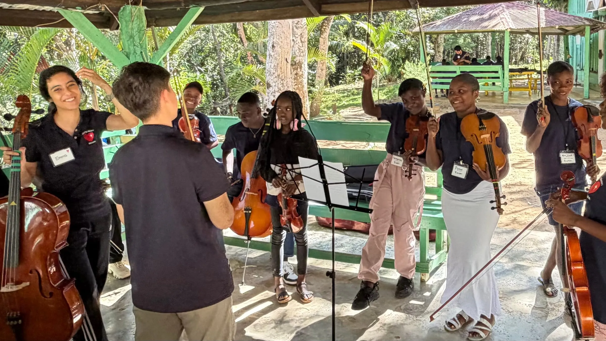A youth orchestra performs under a pavilion